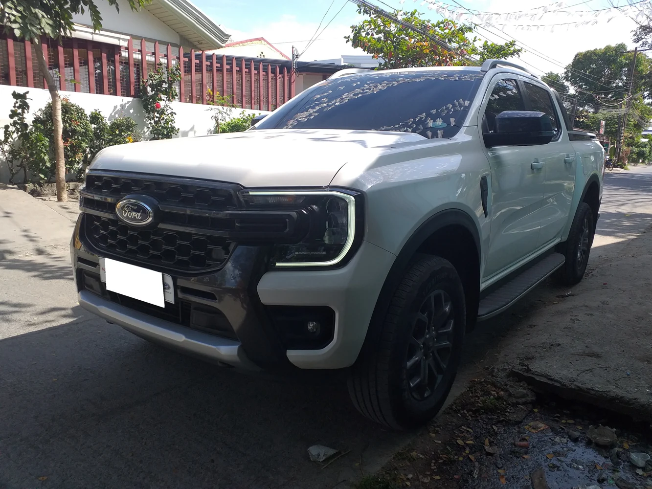 Ford Pick-up blanca estacionada en una calle, fotografía referencial
